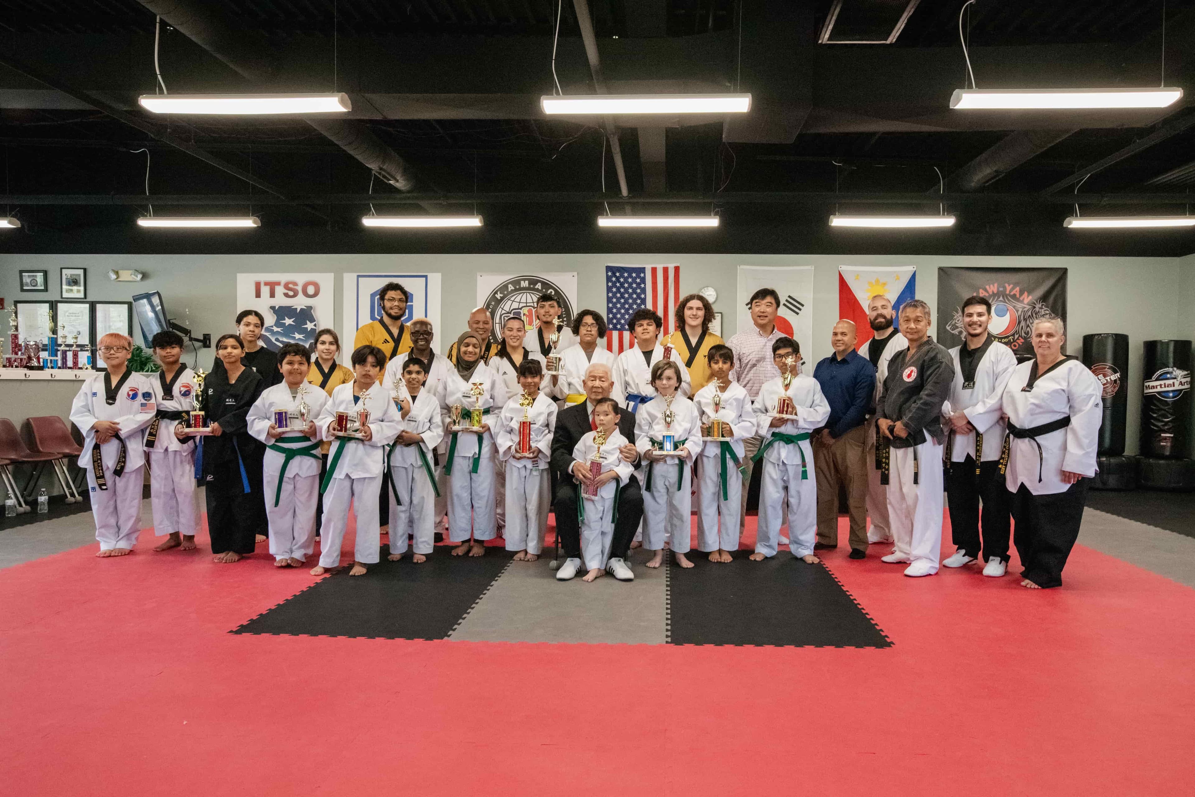 The masters, instructors, and young students holding up their testing trophies